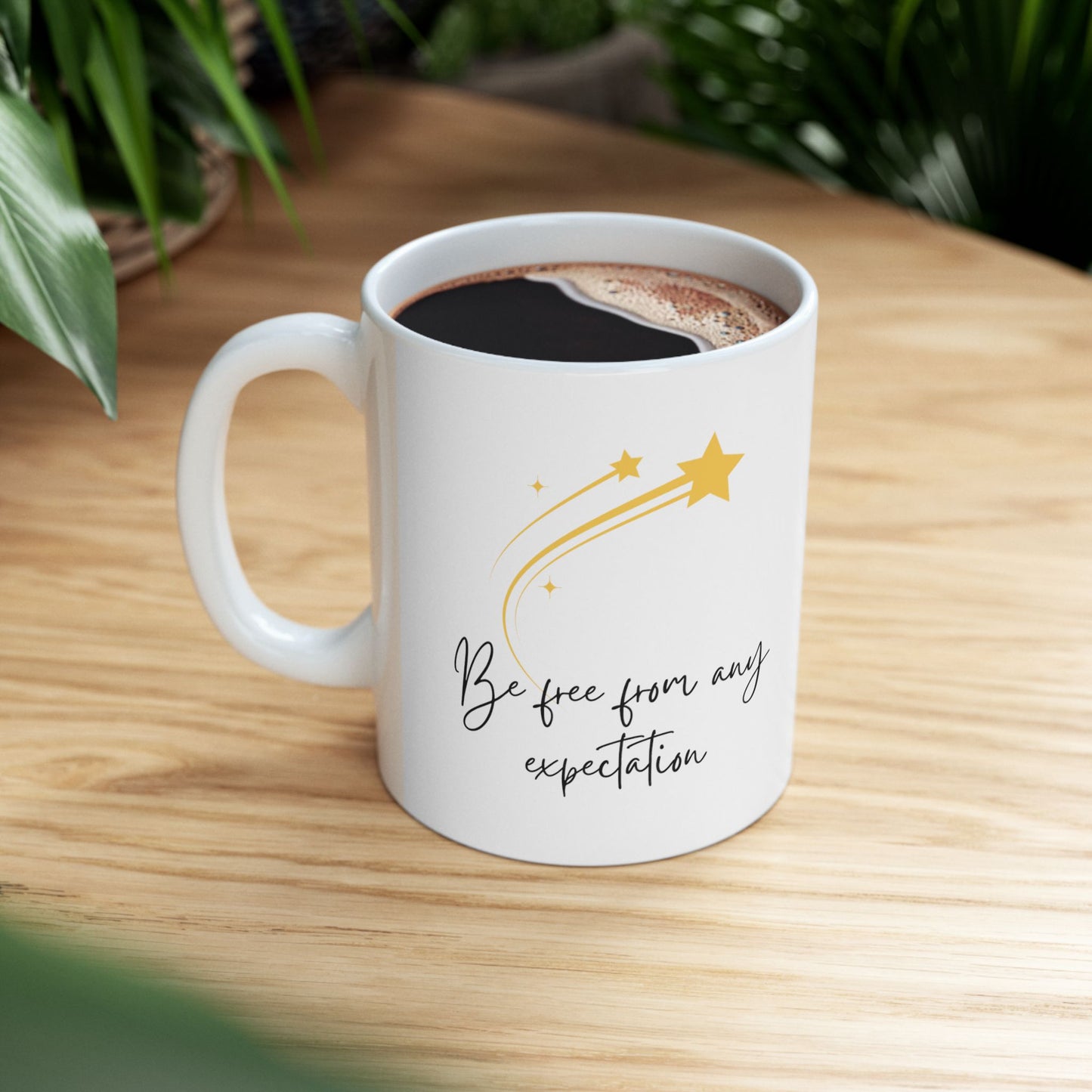 White ceramic mug with the text Be Free From Any Expectation on the both sides of the mug. Also the image of one bigger and three smaller stars on the mug. Mug size 11 oz.