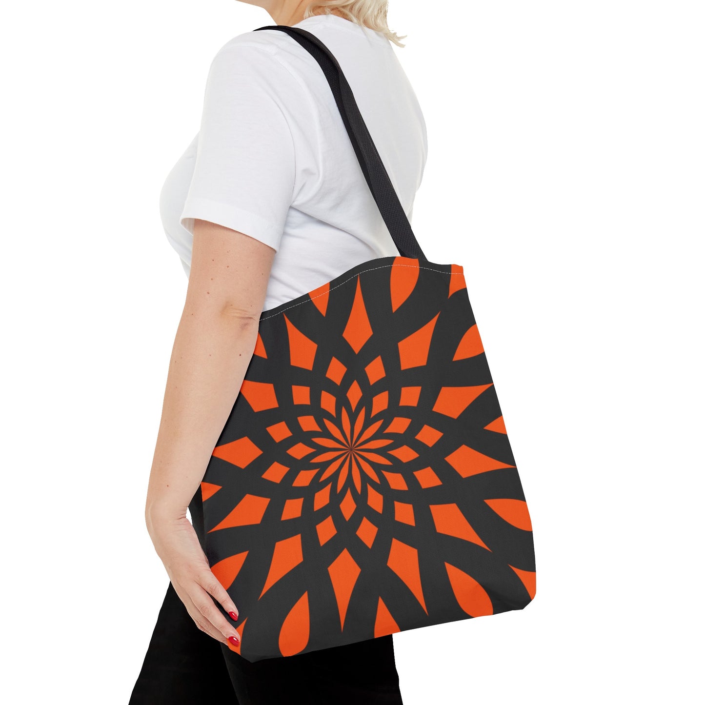 Orange tote bag with the print of mandala like pattern in black. Made with 100% polyester. It is highly durable and perfect for everyday use. A bag is non-woven laminate inside, cotton handles, and are available in 3 sizes, 1x large storage compartment.