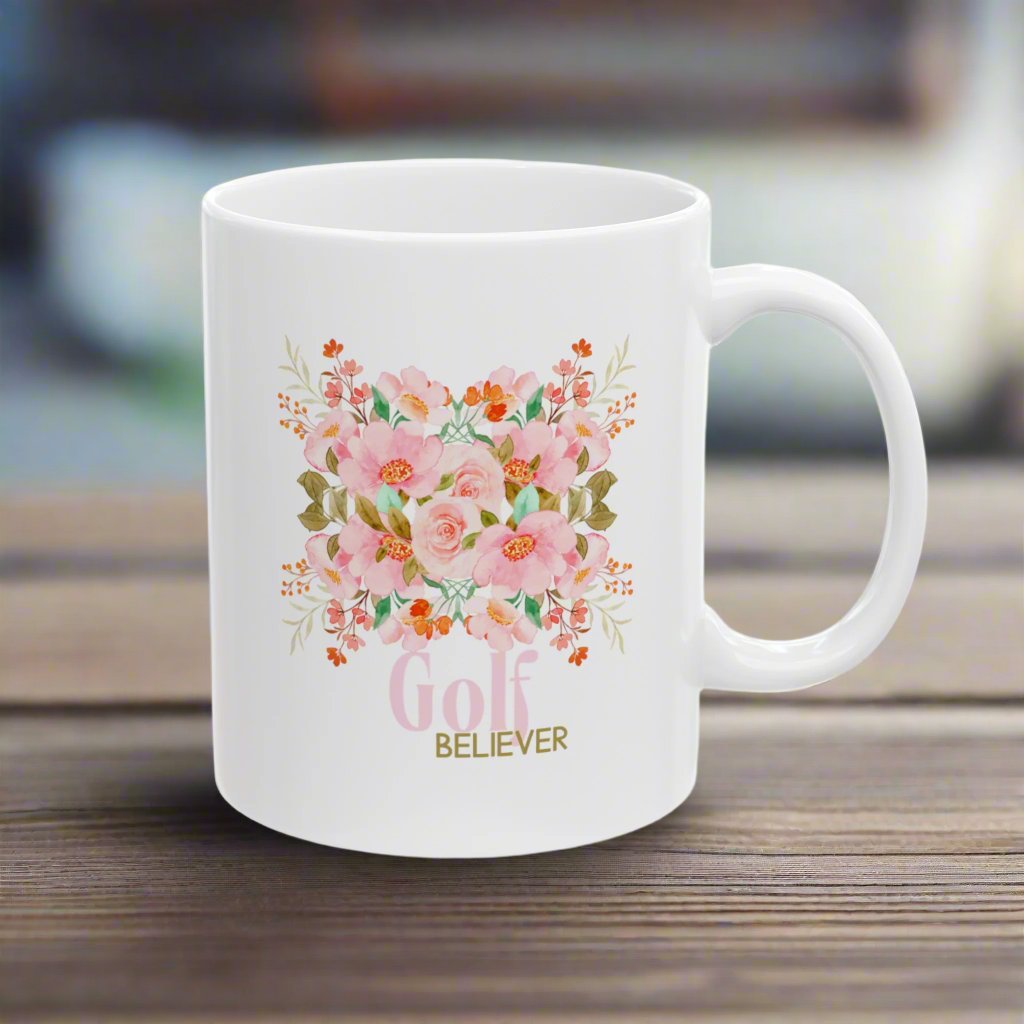 Favorite white ceramic coffee, tee or chocolate mug. The “Golf Believer” design features a blend of golf enthusiasm and blooming flowers, making it a unique choice for golf lovers.