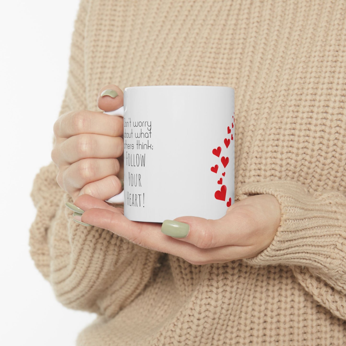 White ceramic mug with red hearts in the middle and the text on the both sides of the mug: Don't Worry About What Others Think, Follow Your Heart.