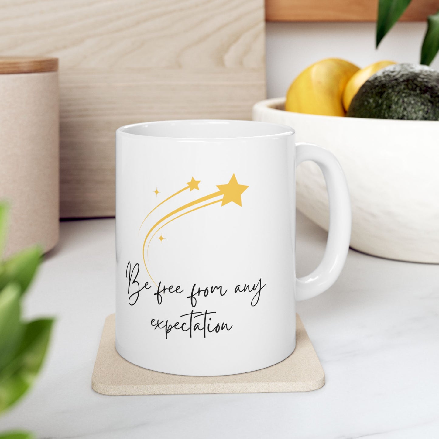 White ceramic mug with the text Be Free From Any Expectation on the both sides of the mug. Also the image of one bigger and three smaller stars on the mug. Mug size 11 oz.
