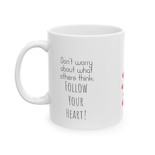 White ceramic mug with red hearts in the middle and the text on the both sides of the mug: Don't Worry About What Others Think, Follow Your Heart.
