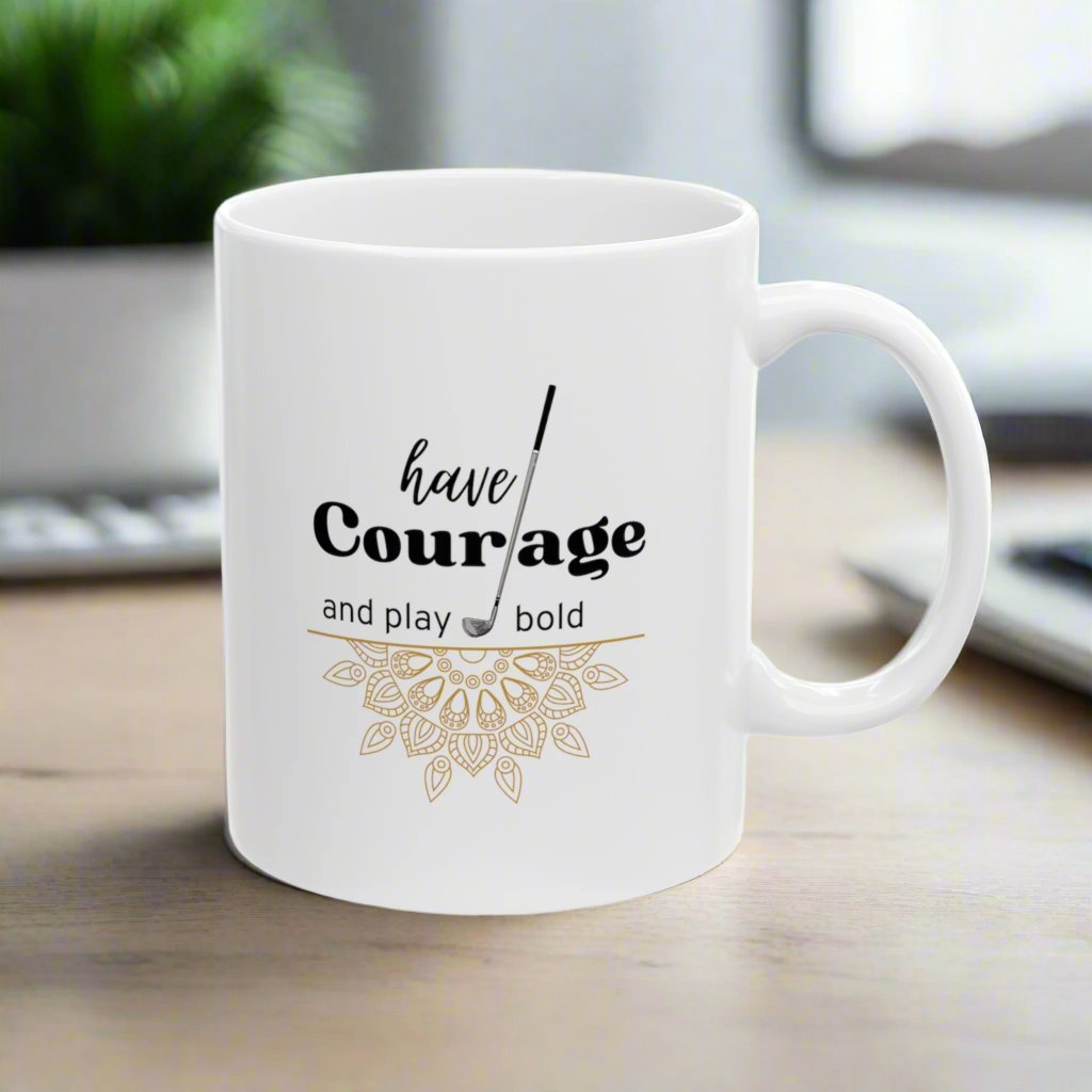 The "Have Courage and Play Bold" golf-themed ceramic mug with the image of mandala and golf club. This 11oz white mug is the perfect companion for every golf enthusiast, providing a daily dose of inspiration with every sip. 