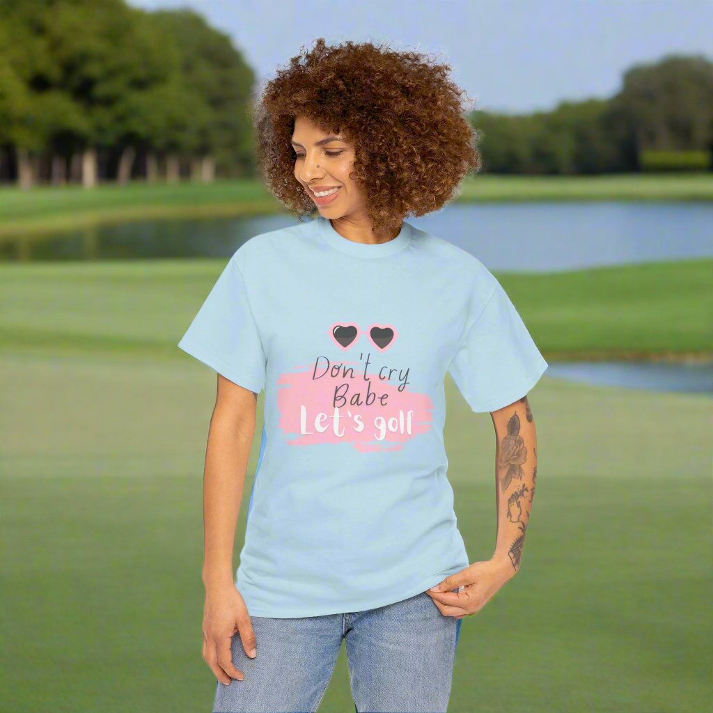 Light blue tshirt with the text Don't cry Babe, let's golf and the image of heart shaped glasses.