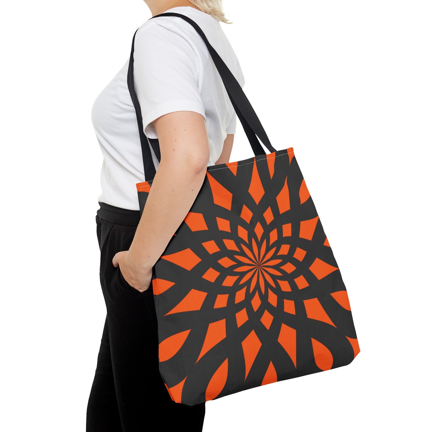 Orange tote bag with the print of mandala like pattern in black. Made with 100% polyester. It is highly durable and perfect for everyday use. A bag is non-woven laminate inside, cotton handles, and are available in 3 sizes, 1x large storage compartment.