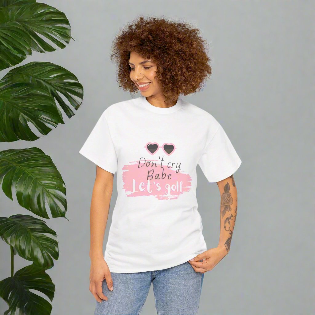 White tshirt with the text Don't cry Babe, let's golf and the image of heart shaped glasses.