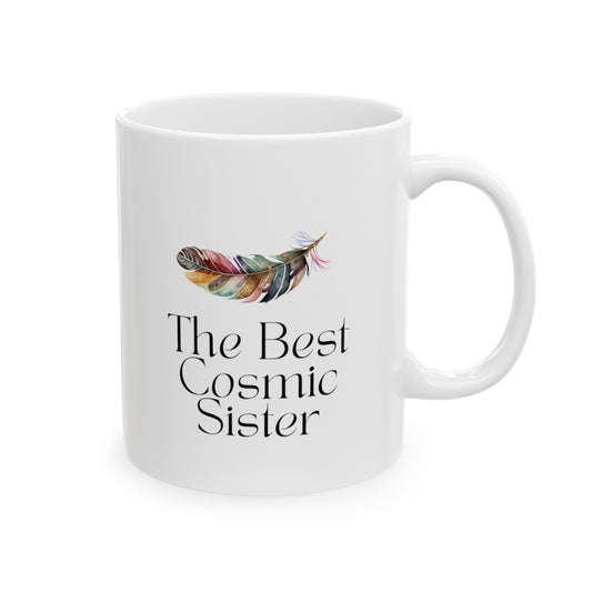 White ceramic mug with the text The best cosmic sister and with the image of multicolor feather. Size of 11 oz.